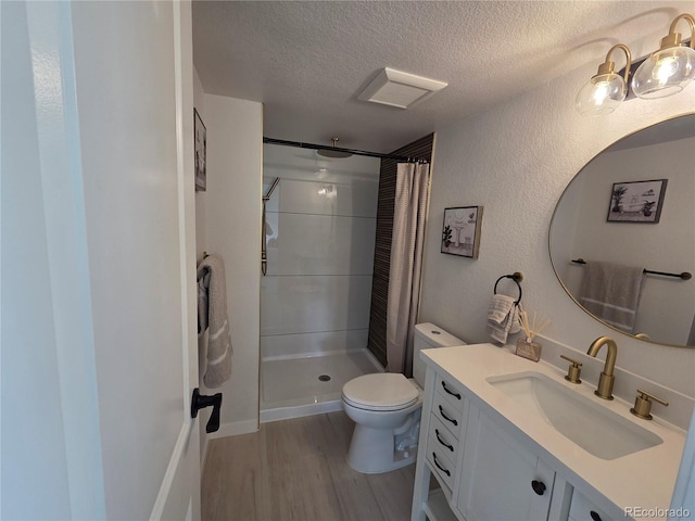 14433 E Jewell Ave Unit 101, Aurora, CO 80012 - full bathroom featuring wood finished floors, curtained shower, vanity, and a textured ceiling