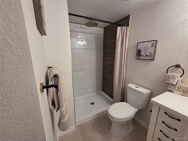 14433 E Jewell Ave Unit 101, Aurora, CO 80012 - full bathroom featuring a textured wall, a shower with curtain, wood finished floors, a textured ceiling, and vanity