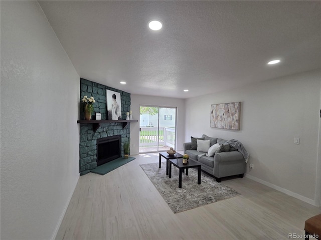 14433 E Jewell Ave Unit 101, Aurora, CO 80012 - living area featuring wood finished floors, a textured ceiling, recessed lighting, and a fireplace