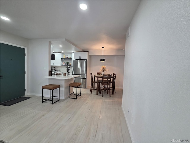 14433 E Jewell Ave Unit 101, Aurora, CO 80012 - kitchen featuring freestanding refrigerator, open shelves, a kitchen bar, a peninsula, and recessed lighting
