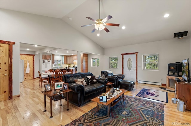 33002 Bobcat Ct, Trinidad, CO 81082 - living area with a baseboard heating unit, light wood-type flooring, ceiling fan, a wood stove, and high vaulted ceiling