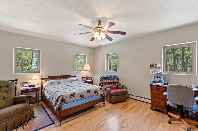 33002 Bobcat Ct, Trinidad, CO 81082 - bedroom featuring baseboard heating, light wood-type flooring, and ceiling fan