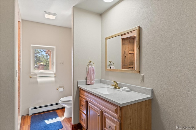 33002 Bobcat Ct, Trinidad, CO 81082 - bathroom with a baseboard radiator, vanity, wood finished floors, and toilet