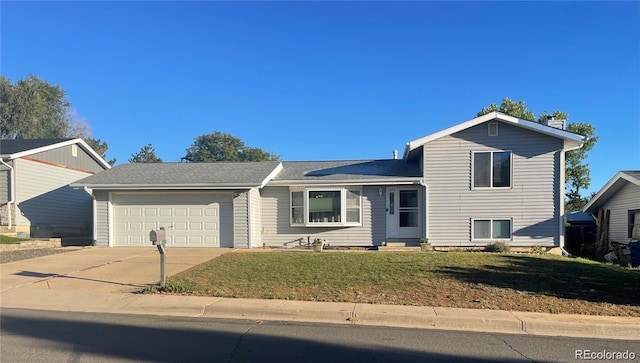 tri-level home featuring driveway, a front yard, and a garage