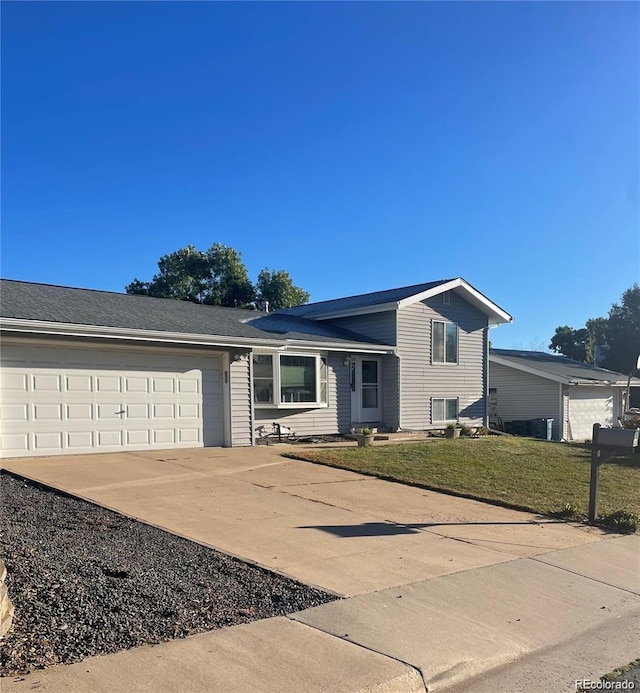 tri-level home featuring a garage, driveway, and a front lawn