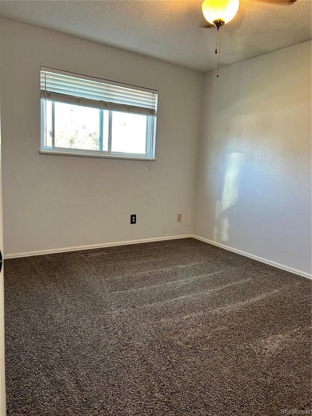 carpeted spare room with a textured ceiling and baseboards