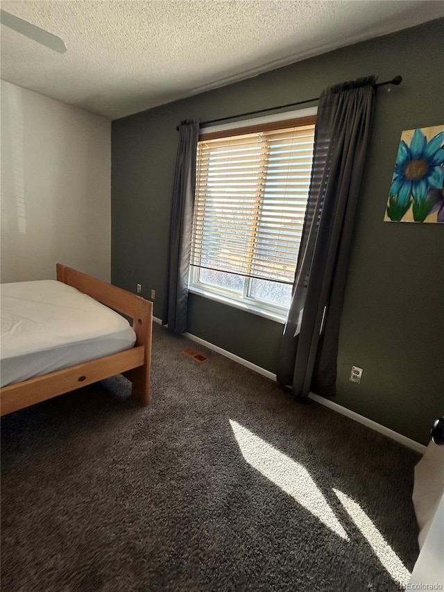 bedroom with visible vents, carpet, baseboards, and a textured ceiling