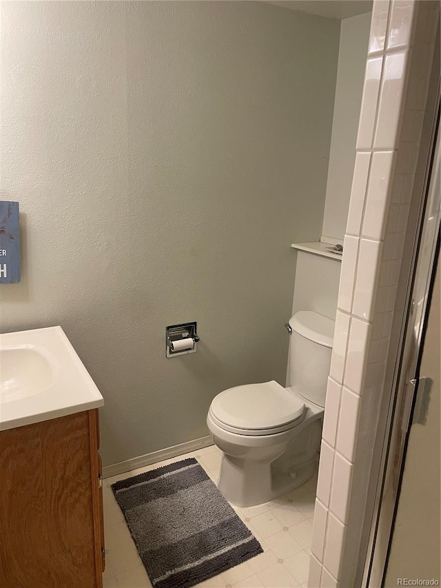 bathroom with vanity, toilet, and baseboards