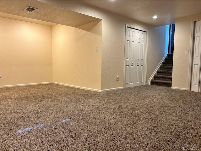 finished below grade area with baseboards, visible vents, and carpet floors