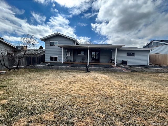 back of house with fence and a lawn