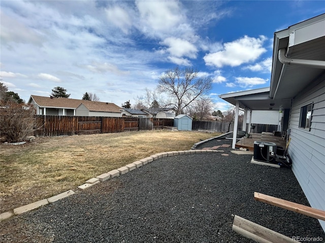 view of yard featuring a patio, a shed, a fenced backyard, central AC, and an outdoor structure