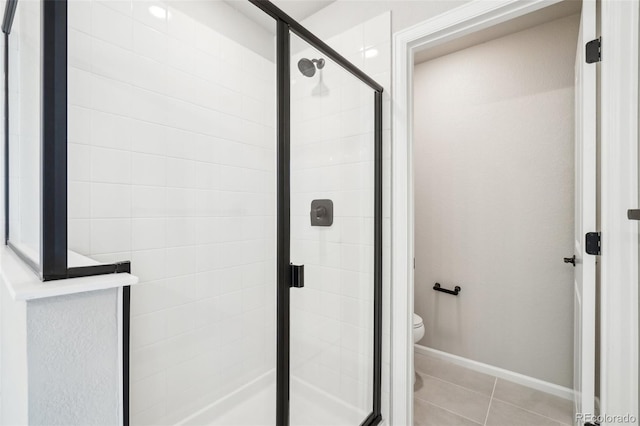 bathroom with toilet, tile patterned flooring, and a shower with shower door