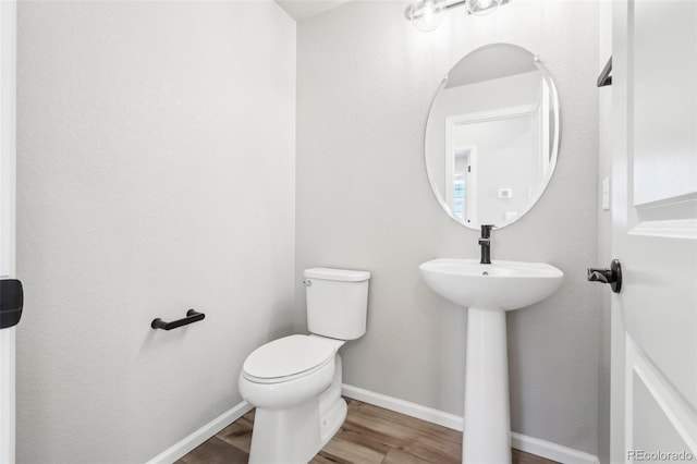 bathroom with toilet and wood-type flooring