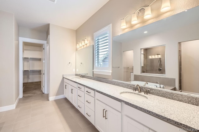 8778 S Quatar St, Aurora, CO 80016 - full bath featuring double vanity, tile patterned flooring, and a walk in closet