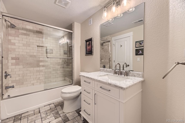 8778 S Quatar St, Aurora, CO 80016 - bathroom featuring a textured wall, vanity, shower / bath combination with glass door, and a textured ceiling