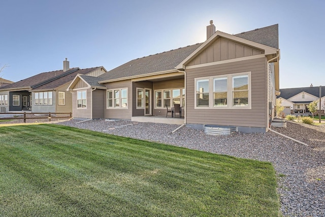 8778 S Quatar St, Aurora, CO 80016 - back of house featuring a yard, a chimney, board and batten siding, a patio area, and a shingled roof