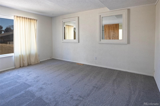 unfurnished room with carpet flooring, a textured ceiling, and baseboards