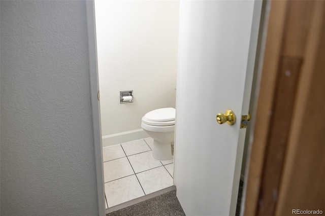 bathroom featuring toilet, baseboards, and tile patterned floors