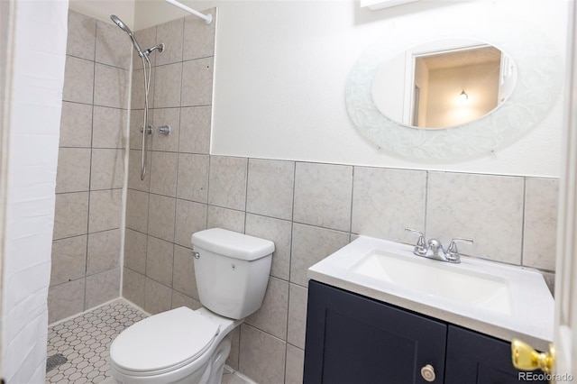bathroom with toilet, tile walls, vanity, and a shower stall