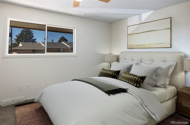 bedroom featuring carpet floors, a textured ceiling, visible vents, baseboards, and ceiling fan