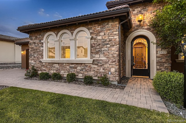 9453 Vista Hill Ln, Lone Tree, CO 80124 - view of exterior entry featuring stone siding and a tiled roof