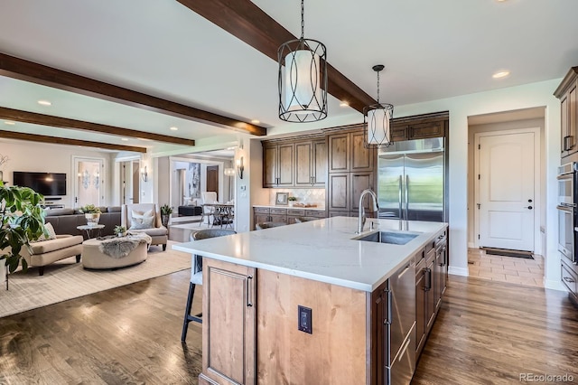 9453 Vista Hill Ln, Lone Tree, CO 80124 - kitchen featuring beam ceiling, open floor plan, wood finished floors, stainless steel built in fridge, and hanging light fixtures