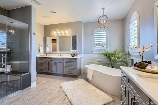 9453 Vista Hill Ln, Lone Tree, CO 80124 - bathroom featuring a chandelier, two vanities, a stall shower, and a freestanding bath
