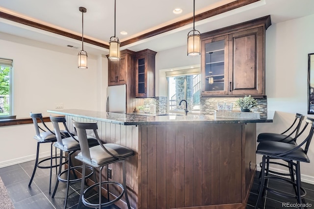 9453 Vista Hill Ln, Lone Tree, CO 80124 - kitchen with tasteful backsplash, freestanding refrigerator, a breakfast bar, dark stone countertops, and recessed lighting