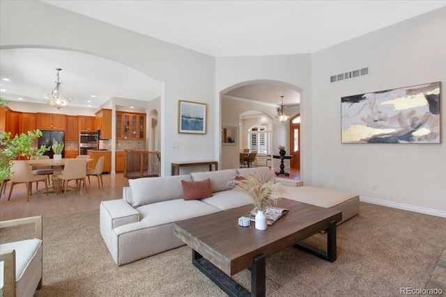 6703 S Yates Ct, Littleton, CO 80128 - living area with arched walkways, a chandelier, recessed lighting, and light colored carpet