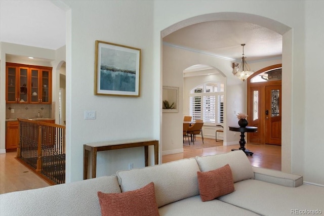 6703 S Yates Ct, Littleton, CO 80128 - living room featuring arched walkways, a chandelier, and light wood-type flooring