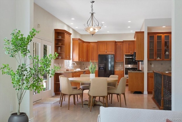 6703 S Yates Ct, Littleton, CO 80128 - kitchen with black fridge with ice dispenser, open shelves, stainless steel double oven, recessed lighting, and backsplash