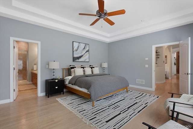 6703 S Yates Ct, Littleton, CO 80128 - bedroom featuring light wood-style flooring, a raised ceiling, and arched walkways