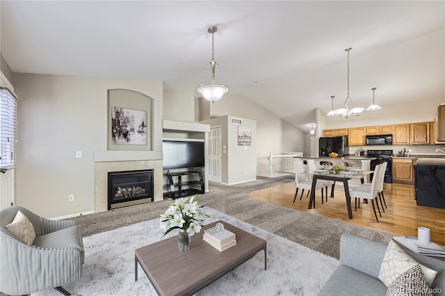 carpeted living room featuring a fireplace and vaulted ceiling