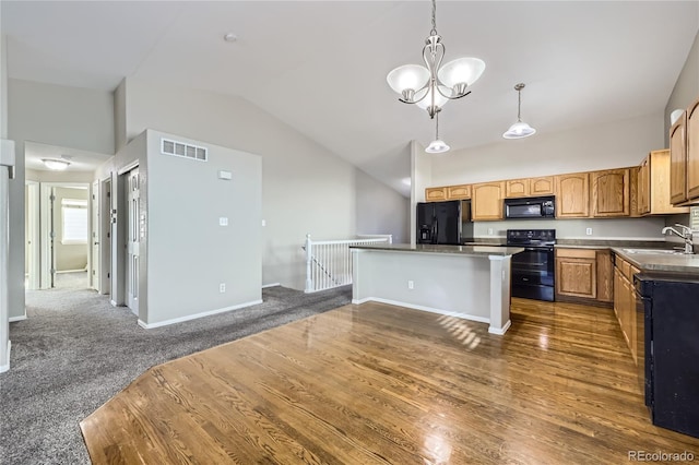 kitchen with a kitchen island, pendant lighting, sink, a breakfast bar area, and black appliances