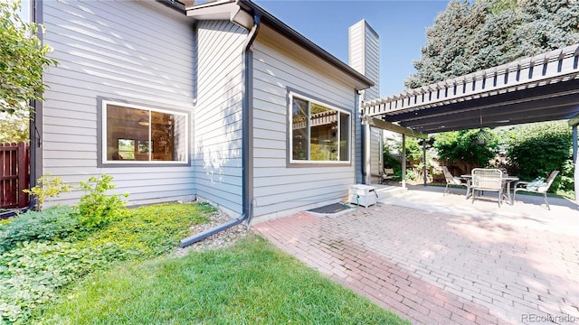 14633 W 69th Pl, Arvada, CO 80004 - view of side of home with a chimney, a patio, and outdoor dining area