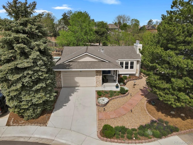 7466 E Long Cir, Centennial, CO 80112 - split level home with a shingled roof, concrete driveway, an attached garage, a chimney, and view of wooded area