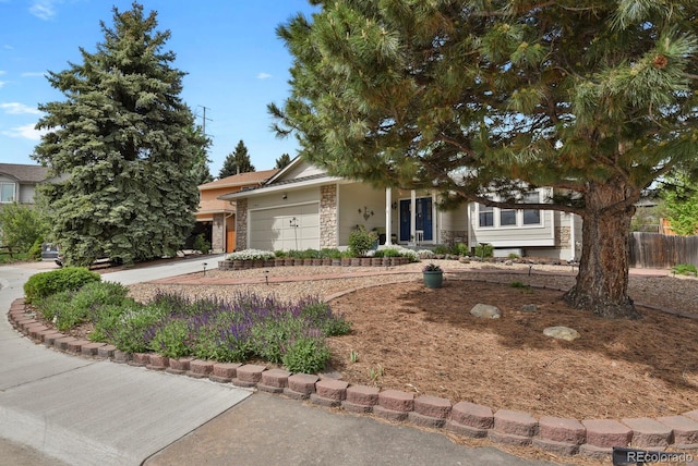 7466 E Long Cir, Centennial, CO 80112 - view of property hidden behind natural elements featuring stone siding, a garage, concrete driveway, and fence