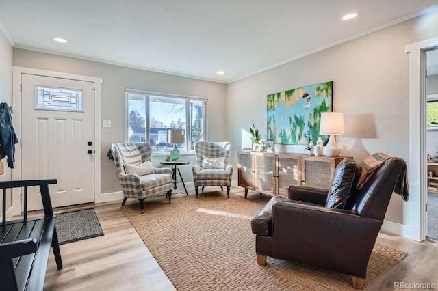 living area featuring light hardwood / wood-style flooring and ornamental molding