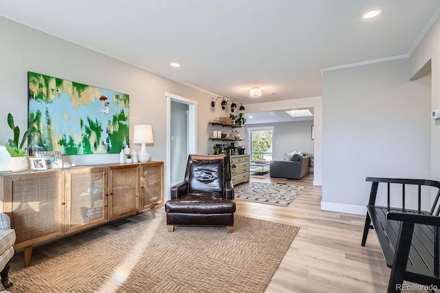 sitting room with light hardwood / wood-style floors and ornamental molding