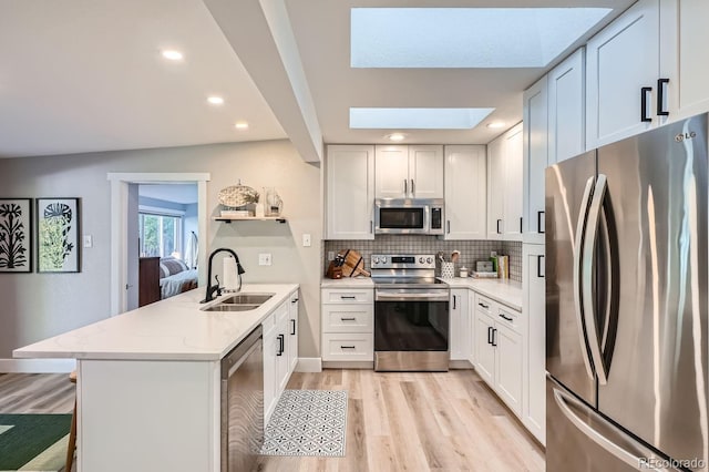 kitchen with white cabinetry, sink, kitchen peninsula, and stainless steel appliances