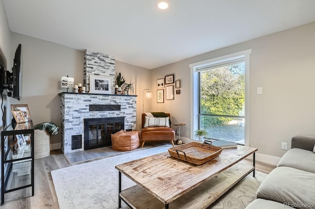 living room with light wood-type flooring and a fireplace