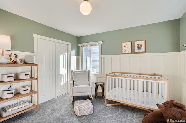 bedroom with a crib, carpet flooring, and a closet