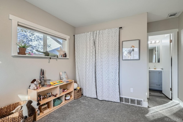 bedroom with dark carpet and ensuite bath