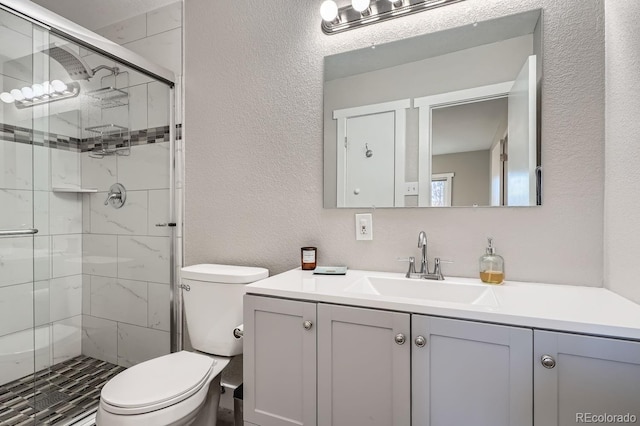 bathroom with vanity, toilet, and a shower with door