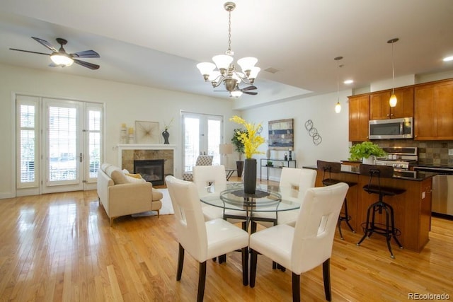 1950 N Logan St Unit 102, Denver, CO 80203 - dining room with light wood-type flooring, a chandelier, a ceiling fan, a fireplace, and recessed lighting