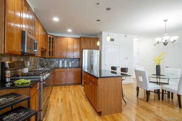 1950 N Logan St Unit 102, Denver, CO 80203 - kitchen featuring stainless steel appliances, brown cabinets, dark countertops, and light wood-style floors