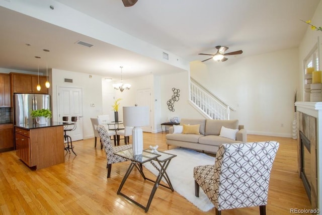 1950 N Logan St Unit 102, Denver, CO 80203 - living area featuring a ceiling fan, light wood finished floors, stairs, a glass covered fireplace, and a chandelier