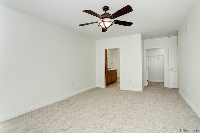 1950 N Logan St Unit 102, Denver, CO 80203 - unfurnished bedroom featuring light carpet, a spacious closet, ensuite bath, and a ceiling fan