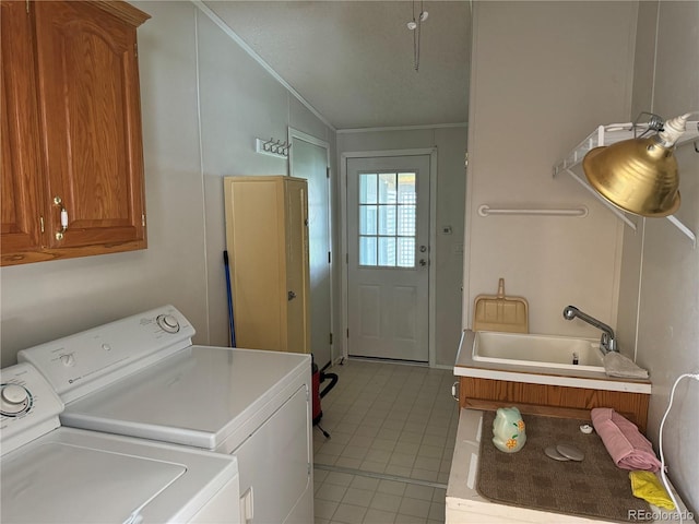 washroom featuring washing machine and dryer, cabinets, light tile patterned floors, and sink