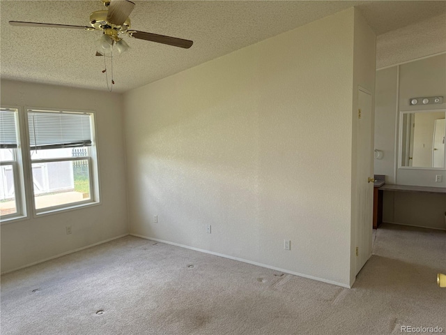 carpeted empty room featuring a textured ceiling and ceiling fan